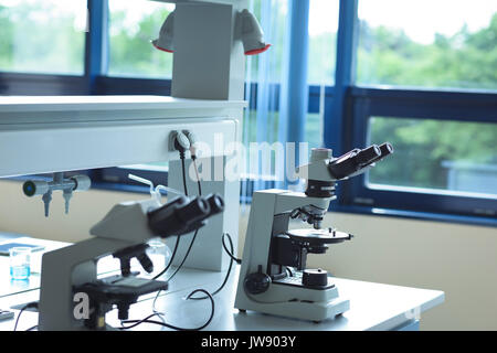 Microscope Lab Center Table Microscope on table in the laboratory. Line of microscopes on tables in ...