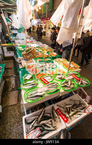 Popular Omicho indoor fresh fish market at Kanazawa, Japan. Fish stall with various types of fish and seafood in green plastic baskets Stock Photo
