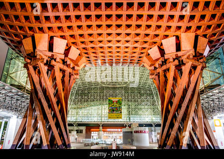 Landmark Tsuzumi gate, aka drum gate, at Kanazawa station, Japan. Night time after rain. View through gate to glass Motenashi dome. Few people Stock Photo