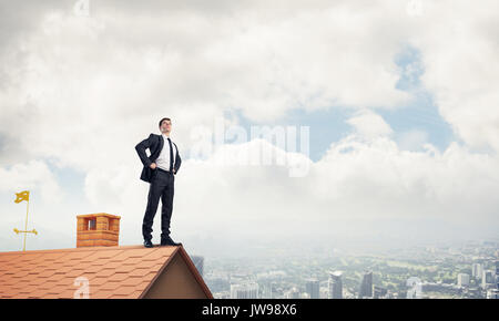 Mister boss on brick roof with arms akimbo. Mixed media Stock Photo