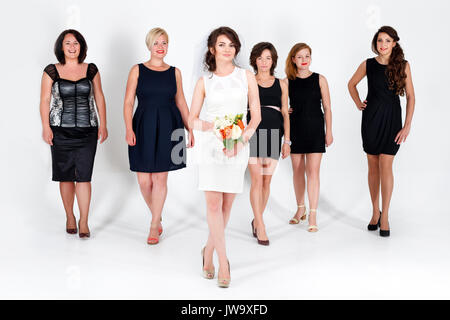 Stylish bridesmaids having fun with bride. Cheerful happy girls celebrate a bachelorette party of bride. Studio shoot. Stock Photo