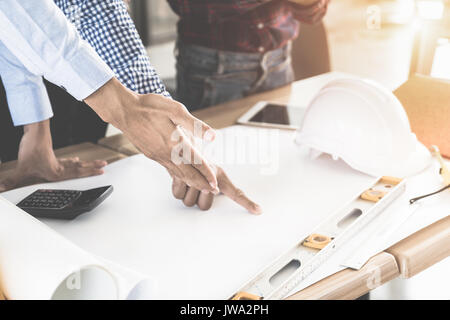 Image of engineer meeting for architectural project. working with partner and engineering tools on workplace. Engineer, discussing, architect concept. Stock Photo