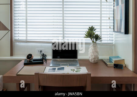 Home freelance desktop with laptop computer, cup of coffee and green plant lying on the table, electronic business distance work via internet at home. Stock Photo