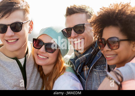 happy teenage friends in shades talking on street Stock Photo