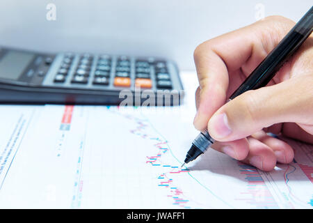 Businessman hand holding a pen working on document. Stock Photo