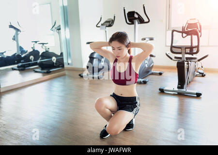 Young fitness woman executed exercise in gym. Stock Photo