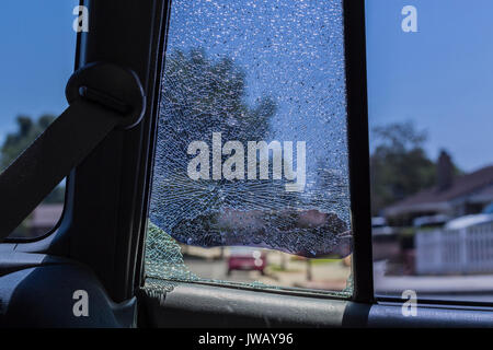 Smashed rear car door window from vehicle burglary.  Inside looking out. Stock Photo