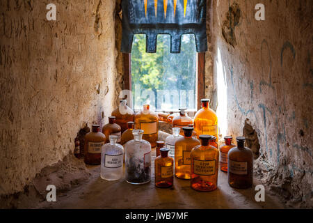 Old pharmacy bottles with latin names. Room of medieval doctor in castle. Stock Photo