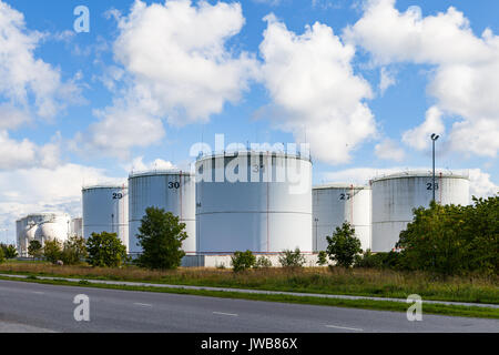 Silver oil tanks on the green grass field. Blue sky with clouds Stock ...
