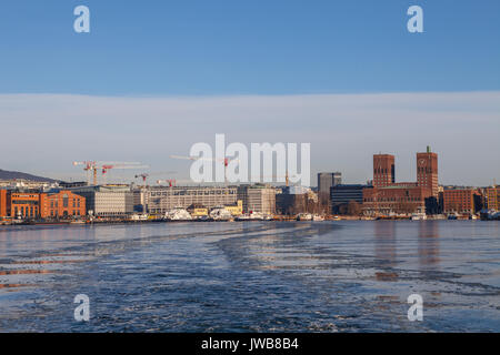 Harbour with boats, new buildings and town hall on background at sunset in Oslo, Norway Stock Photo