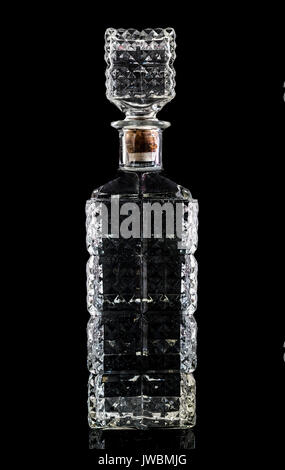 Luxurious adorned and textured glass vodka bottle, with cork cap, on black background and reflective surface Stock Photo