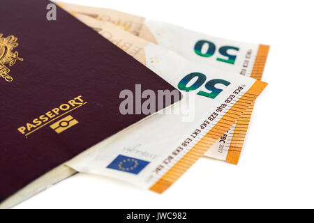 100 euro bills banknotes inserted between pages of european French passport. Concept price travel, backchich. Front and top view, close-up Stock Photo