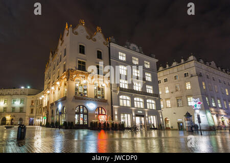 KRAKOW, POLAND - JANUARY 12, 2017: Unrecognized people walk along Hard Rock Cafe on Main Market square in old town at night. Krakow is the second larg Stock Photo