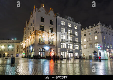 KRAKOW, POLAND - JANUARY 12, 2017: Unrecognized people walk along Hard Rock Cafe on Main Market square in old town at night. Krakow is the second larg Stock Photo