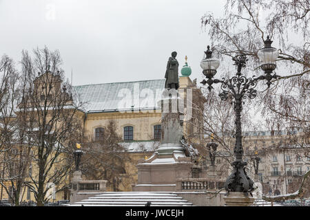 WARSAW, POLAND - JANUARY 16, 2017: Monument of great poet Adam Mickiewicz and Carmelite church at famous Krakowskie Przedmiescie street in winter. War Stock Photo