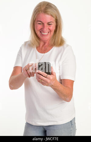 attractive middle-aged woman looking at or texting on a cell Stock Photo
