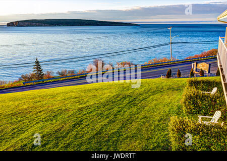 Perce, Canada - June 7, 2017: Bonaventure Island during sunrise in Gaspe Peninsula, Quebec, Canada, Gaspesie region with blue water and hotel sign Stock Photo