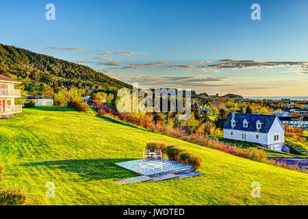 Hotel chairs on hill during sunrise in Perce, Gaspe Peninsula, Quebec, Canada, Gaspesie region with cityscape Stock Photo