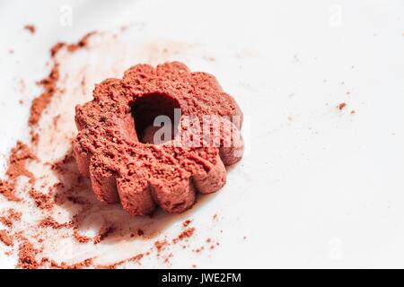 Chocolate biscuits with a sprinkle of ground cocoa beans, on a white plate. Dessert from short pastry. Stock Photo