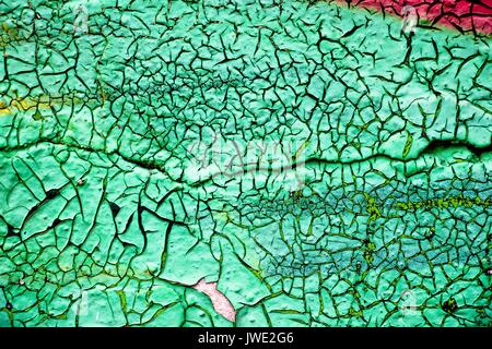 The old wall is painted with green paint, which from time to time has dried up and cracked. Stock Photo