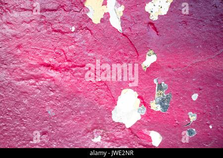 The texture of a red shade of cracked paint on a concrete wall Stock Photo