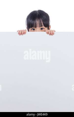 Asian Chinese little girl peeping behind white board in isolated white background Stock Photo