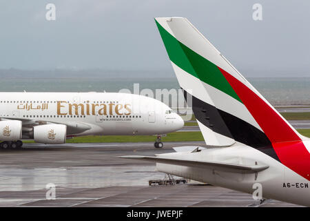 Emirates Airlines Airbus A380 aircraft taxis past the tail of Emirates airlines Boeing 777 aircraft. Stock Photo