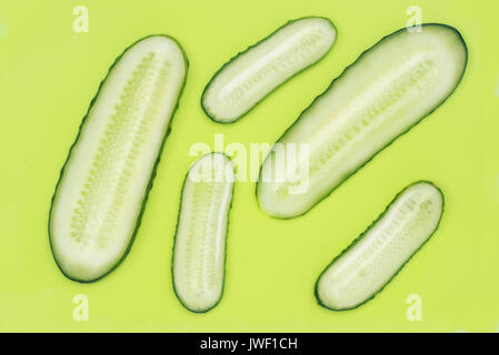 slices of cucumber on green plastic cutting board top view Stock Photo