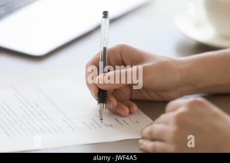 Female hand putting signature on document, signing official pape Stock Photo