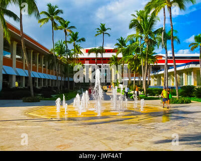 Punta Cana, Dominican republic - February 04, 2013: Ordinary tourists resting in Barcelo Bavaro Beach hotel with pool under palms Stock Photo