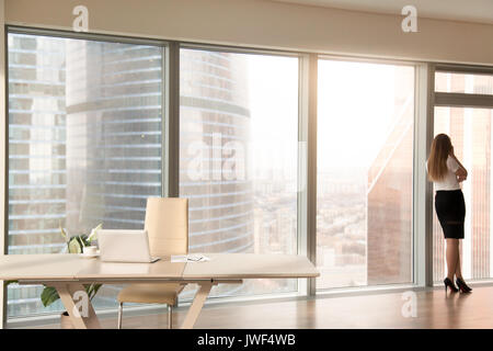 Modern office interior with female silhouette standing at full-l Stock Photo