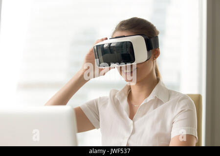 Smiling woman trying vr goggles, first virtual reality helmet ex Stock Photo