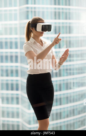 Serious businesswoman in VR headset trying virtual reality 3d to Stock Photo