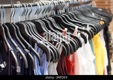 T-shirts made of cotton cloth on hangers in the store Stock Photo