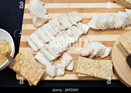 Sliced soft brie cheese and crispy bread on wooden board Stock Photo