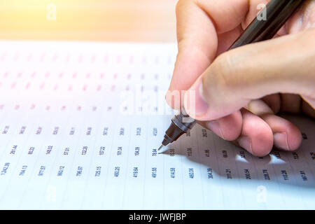 Businessman hand holding a pen working on document. Stock Photo
