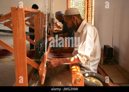 Men weaving colourful silk cloth ad rugs at the Atlas Silk Factory ...
