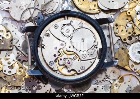 watchmaker workshop - open used mechanical wristwatch on heap of clock spare parts Stock Photo