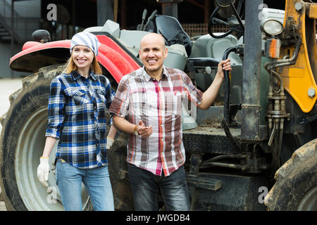 Male driver and assistant opestanding near harvester in livestock farm Stock Photo