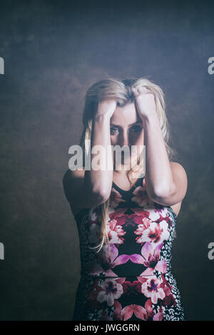Frustrated blond woman head in hands Stock Photo
