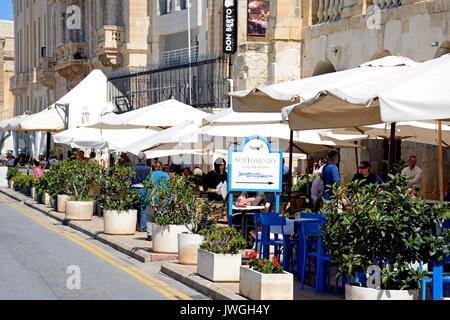 Tourists relaxing at a pavement cafe along the waterfront, Vittoriosa (Birgu), Malta, Europe. Stock Photo