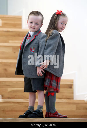 Cooper and Cora Deegan join 13 sets of twins for a photocall as they start primary school in the Inverclyde area at St Patrick's Primary School in Greenock. Stock Photo