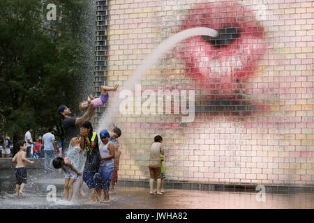 Chicago, USA. 11th Aug, 2017. People play at the Crown Fountain in Millennium Park of downtown Chicago, the United States, on Aug. 11, 2017. Crown Fountain is an interactive work of public art and video sculpture featured in Chicago's Millennium Park. The fountain is composed of a black granite reflecting pool placed between a pair of glass brick towers using LED display to show digital videos on their inward faces. Credit: Wang Ping/Xinhua/Alamy Live News