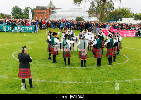 Glasgow, UK. 12th Aug, 2017. It was estimated that more than 10,000 spectators turned out to watch the final day of 'Piping Live' and the World Pipe Band Championships, an Internationally reknowned competition, take place in Glasgow Green as the finale to a week of entertainment and free concerts that have taken place around Glasgow city centre. Despite the occasional heavy rain shower, play continued and spirits weren't dampened. Credit: Findlay/Alamy Live News Stock Photo