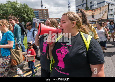 London, UK. 12th August 2017. Jasmin Stone of Focus E15 Mothers leads the chanting of slogans at the start of the march from Ferrier Point in Canning Town to a rally at Tanner Point in Plaistow pointing out the danger of these two blocks with the same cladding as Grenfell Tower, demanding safe homes, not social cleansing in East London.  They then continued to the Carpenters Estate in Stratford largely emptied of people over 10 years ago and intends to demolish, for a ‘hands around the Carpenters Estate’ solidarity Credit: Peter Marshall/Alamy Live News Stock Photo