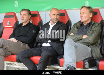 Dortmund's sports director Michael Zorc (L-R), manager Peter Bosz and CEO Hans-Joachim Watzke sit on the bench ahead of the German Soccer Association (DFB) Cup first-round soccer match between 1. FC Rielasingen-Arlen and Borussia Dortmund in the Schwarzwald Stadium in Freiburg, Germany, 12 August 2017. The club has announced that Ousmane Dembele, the young attacking midfielder whose breakout season at the club has led to him being linked with clubs across Europe including Barcelona, will remain suspended from the team 'until further notice'. The announcement was made on Sunday morning at a con Stock Photo