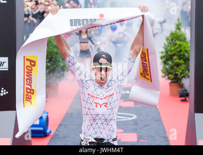 Hamburg, Germany. 13th Aug, 2017. South African athlete and Ironman winner James Cunnama crosses the finish line Lake in Hamburg, Germany, 13 August 2017. Around 2500 athletes swam 3.8 kilometres in the Alster, cycled 180 kilometres through Lower Saxony and Hamburg and ran a 42 kilometre marathon round the Alster lakes. Photo: Daniel Bockwoldt/dpa/Alamy Live News Stock Photo