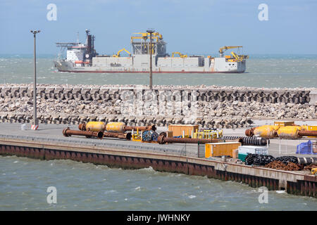HARBOR CALAIS, FRANCE - JUNE 07, 2017: French harbor of Calais with dredging ship navigating outside of the harbor Stock Photo