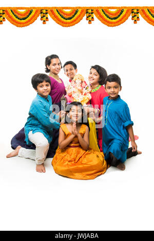 Indian Cute kids holding statue of Lord Ganesha or Ganapati on Ganesh festival or chaturthi, welcoming god. Asian small boys and girls with Lord Ganes Stock Photo