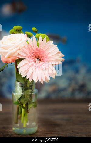 Bouquet of pink roses and gerberas on a wooden background. Blue background Stock Photo